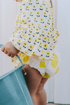Bébé portant la blouse PIA imprimé petites fleurs jaunes et le bloomer BETTY motif citron, vêtements bébé en coton bio certifié GOTS style vintage mixte unisexe
