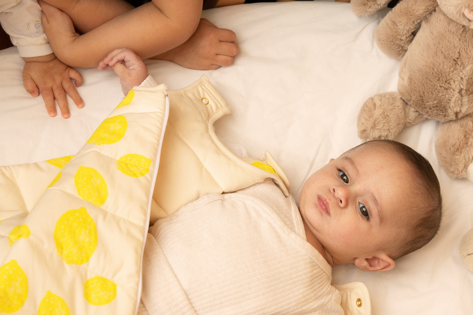 Bébé qui joue dans la gigoteuse à motif citron en coton bio, collection bébé naissance, Baby Care